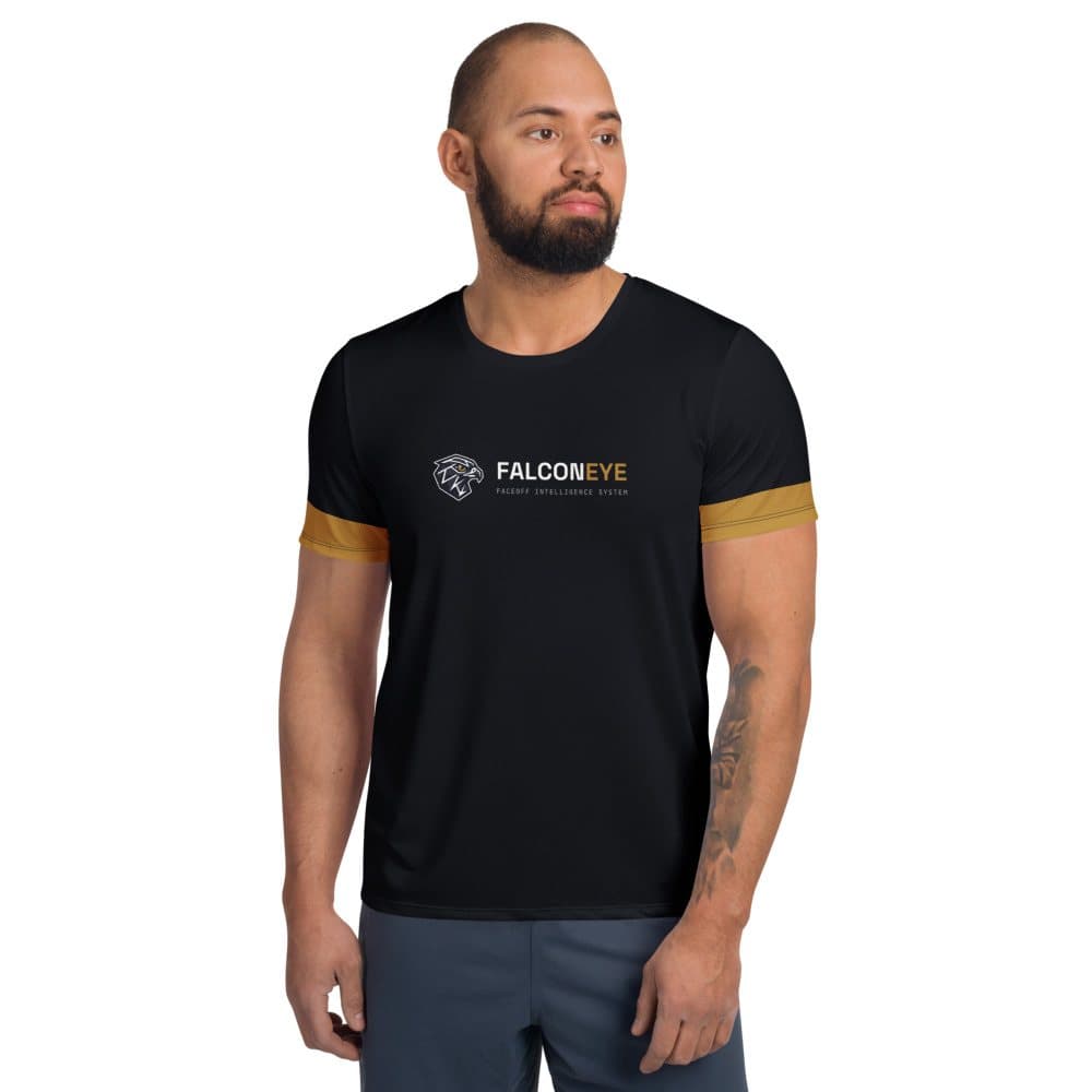 Front of the black FalconEye Performance Tee, center chest on a model: horizontal lockup centered across the chest: the falcon logo on the left, the FALCON in white and EYE in gold wordmark with FACEOFF INTELLIGENCE SYSTEM stacked to its right, with gold bands at both sleeve hems